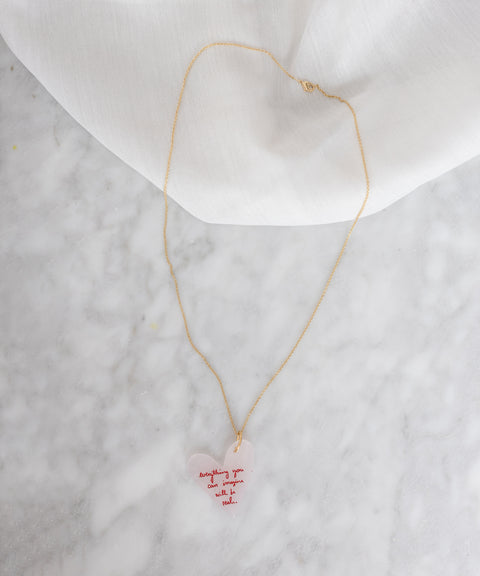 A Let Your Heart Guide You Necklace by WALD Berlin with a pink heart on it.