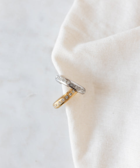 Two stacked Hug Me Earcuff Silver pieces in silver and gold, each set with a row of sparkling Swarovski stones.