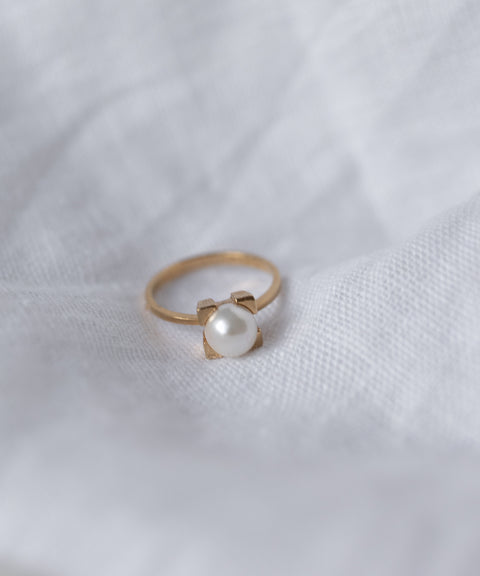 The WALD Berlin SAMPLE SALE Pop Pearl Ring Mini features a minimalist gold plated brass band with a single round pearl, shown on a white textured fabric background.