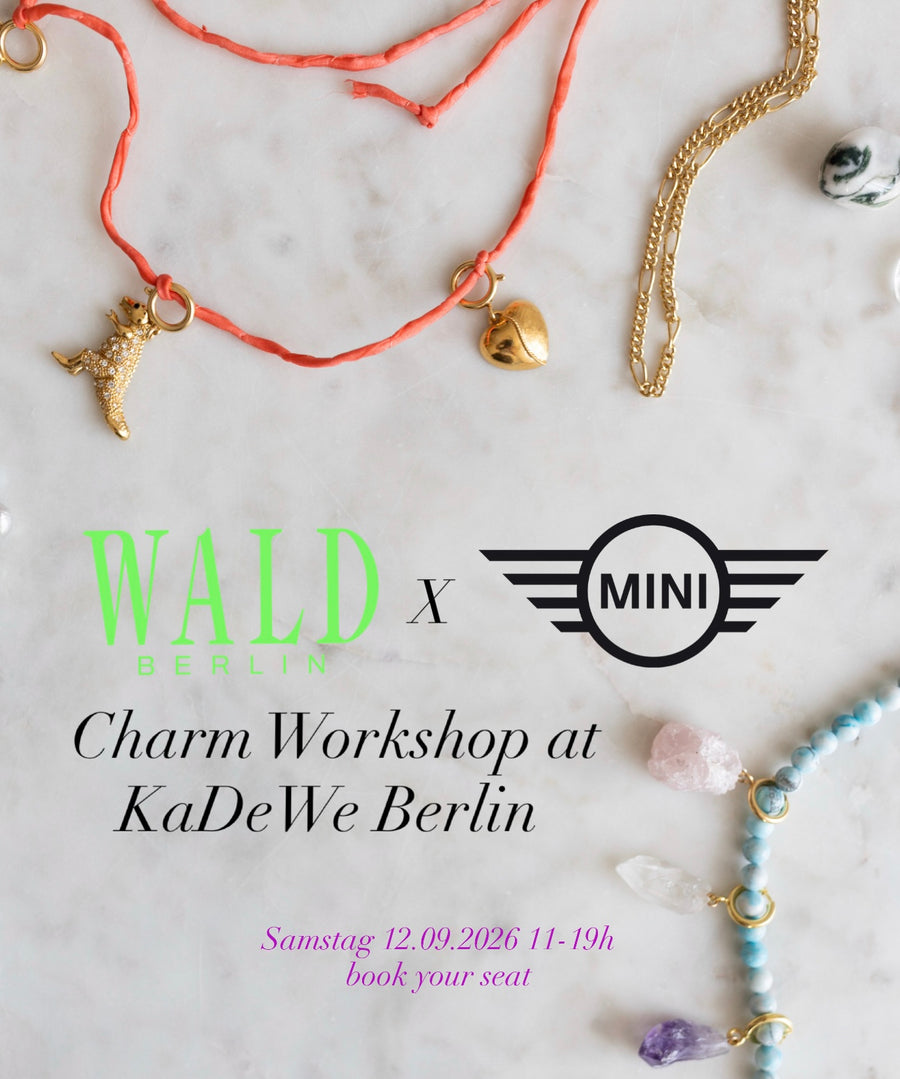 A selection of assorted charm necklaces and jewelry arranged on a marble surface promotes the DIY Schmuck-Workshop x MINI im KaDeWe Berlin by WALD Berlin, taking place on 12.09.2026.