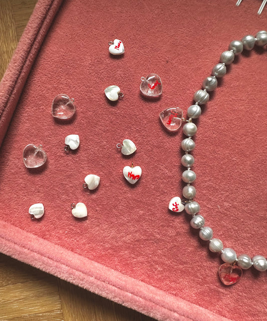 The WALD Berlin Hi Mama pearl heart necklace features assorted heart-shaped beads, ideal as accents for Mother’s Day jewelry or other gold-plated creations.