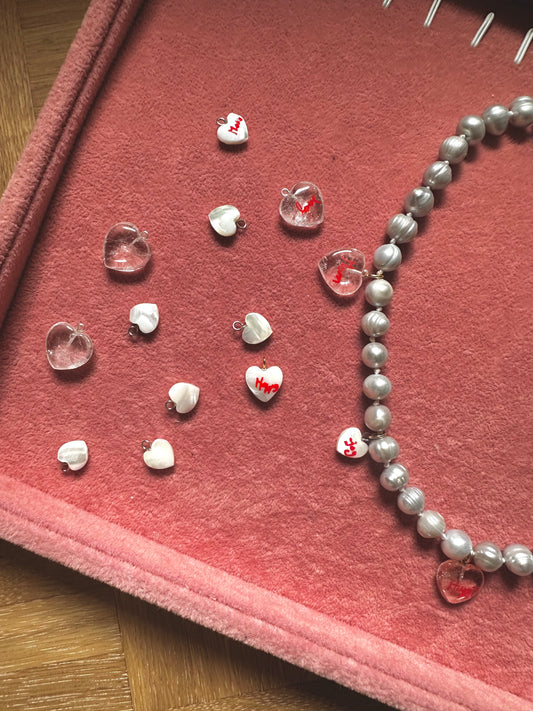 The WALD Berlin Hi Mama pearl heart necklace features assorted heart-shaped beads, ideal as accents for Mother’s Day jewelry or other gold-plated creations.