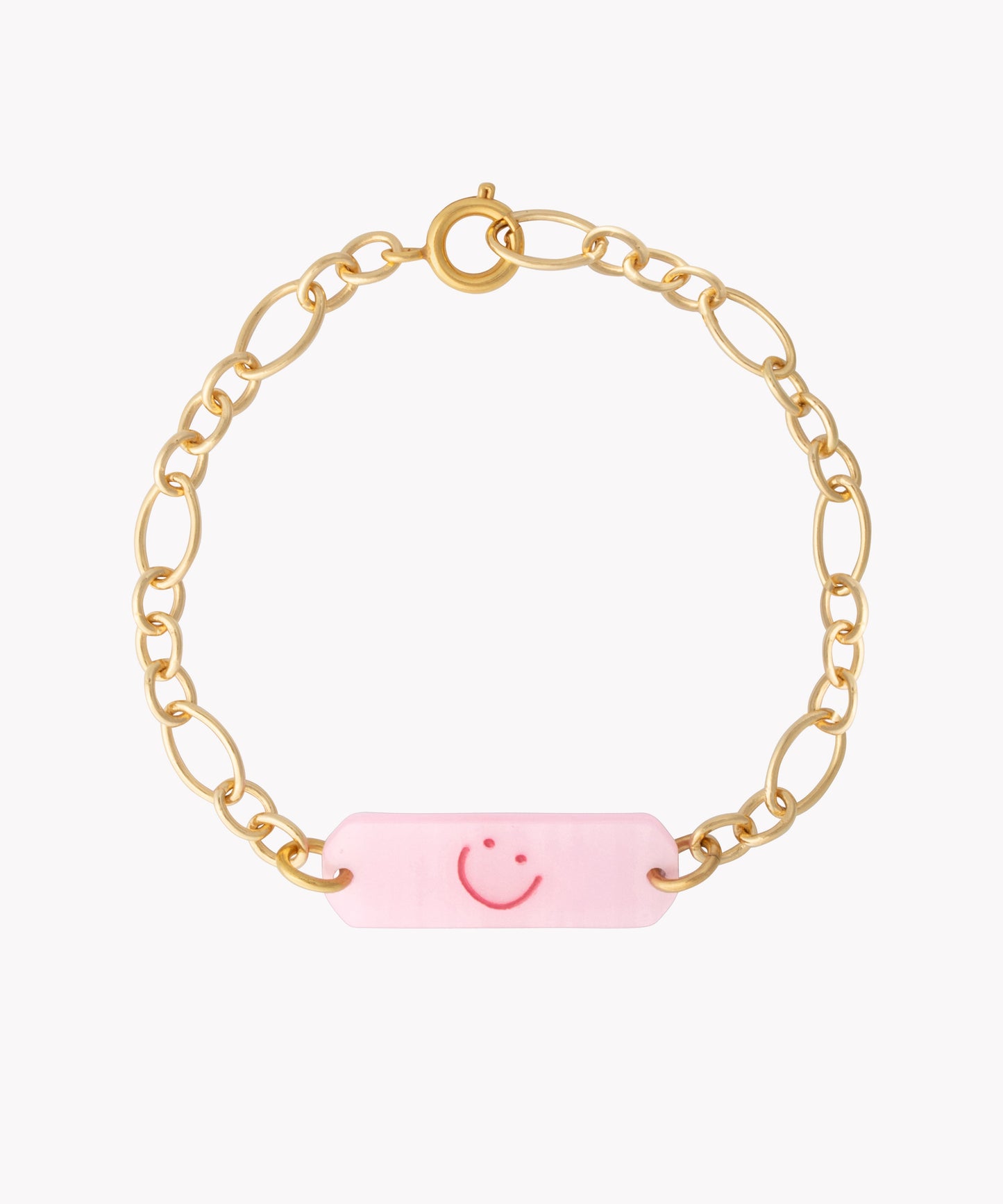 The WALD Berlin Happy ID Rose Bracelet exclusive features an 18k gold plated chain with a pink rectangular charm adorned with a red smiley face, shown on a white background.
