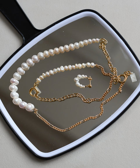 The WALD Berlin Pas De Deux Bracelet / Anklet is elegantly displayed on a black hand mirror, highlighting the brand’s exquisite handmade jewelry design.