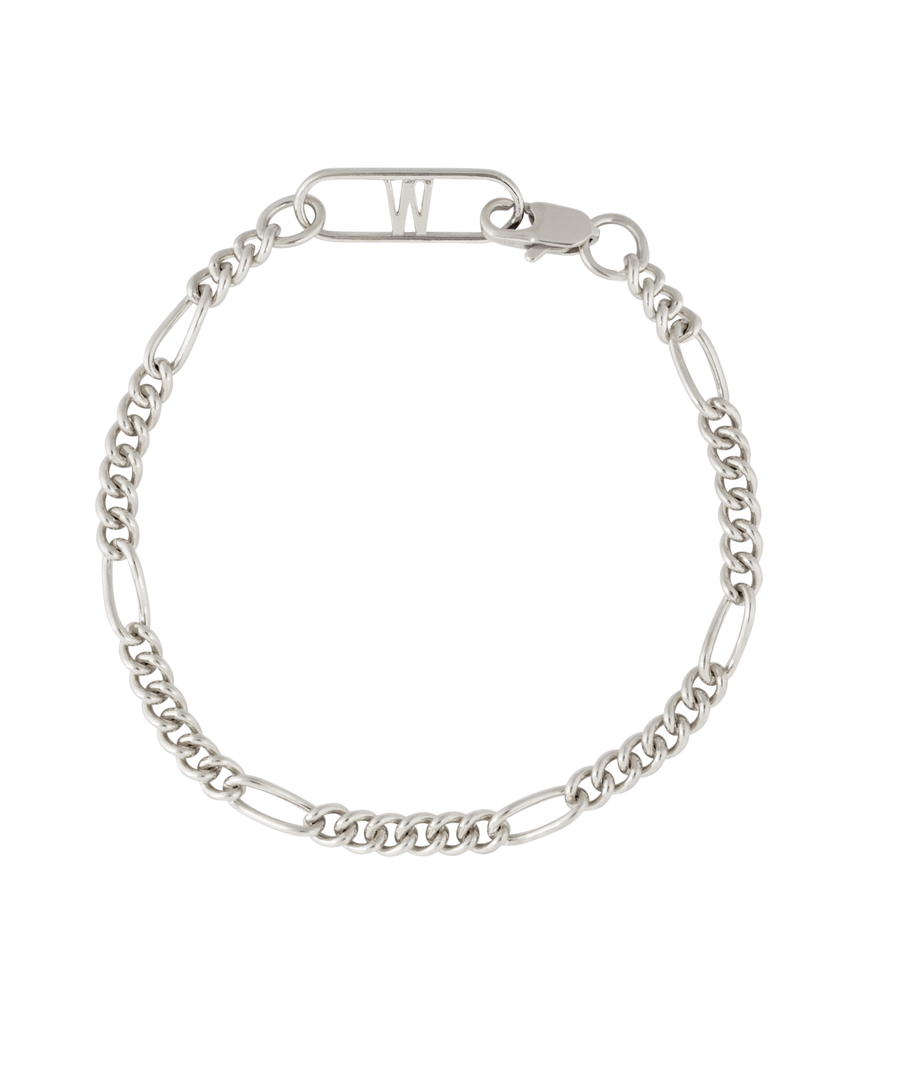 The Naomi Bracelet Silver by WALD Berlin features alternating curb and elongated links, inspired by German design, with a clasp and a bar topped with the letter "W.