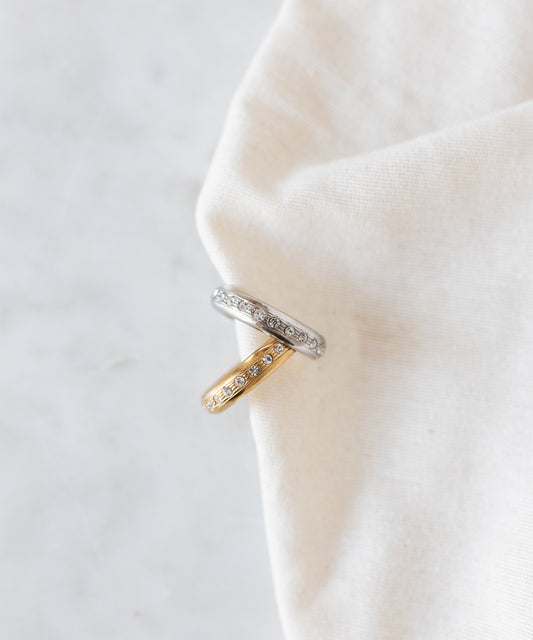 Two stacked Hug Me Earcuff Silver pieces in silver and gold, each set with a row of sparkling Swarovski stones.