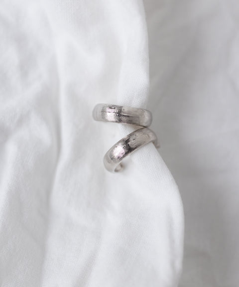 The WALD Berlin SAMPLE SALE Pop Classy Hoop Silver earrings are displayed on a white fabric background.