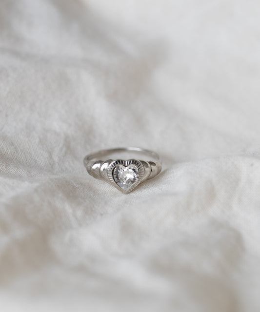 Be My Lover Mini Silver Ring by WALD Berlin on a textured white fabric background.
