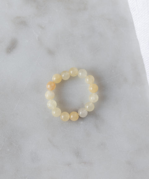 The WALD Berlin Pop Gemstone Ring Set features round, translucent yellow stones and an adjustable fit, displayed on light gray marble—perfect for unique gift ideas.