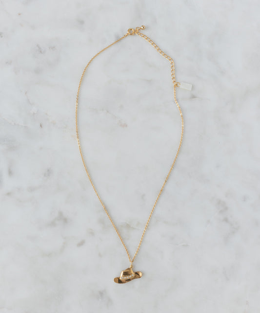 The SAMPLE SALE Pop Cowgirl Necklace by WALD Berlin is a 55cm, 18k gold-plated piece with a small airplane pendant, elegantly displayed on light marble. Made in Germany.