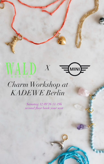 Assorted charm necklaces and bracelets arranged on a marble surface, with text announcing the “DIY Schmuck-Workshop x MINI im KaDeWe Berlin” by WALD Berlin, featuring details on how you can create your own unique jewelry—Schmuck selber machen. Includes date, location at KaDeWe Berlin, and booking information.