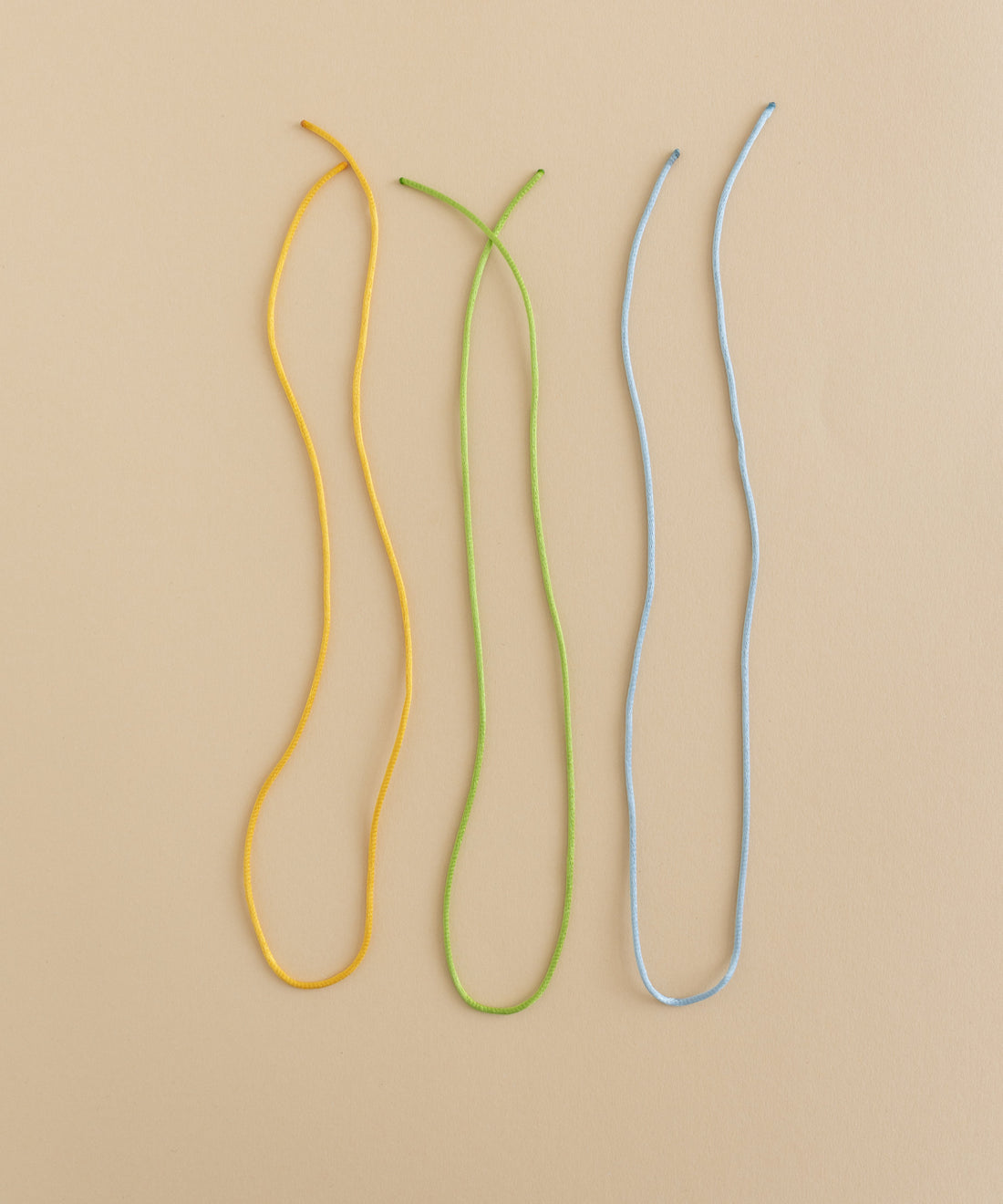 WALD World offers a DIY jewelry kit with three charming ribbon bunt cords on a beige surface.