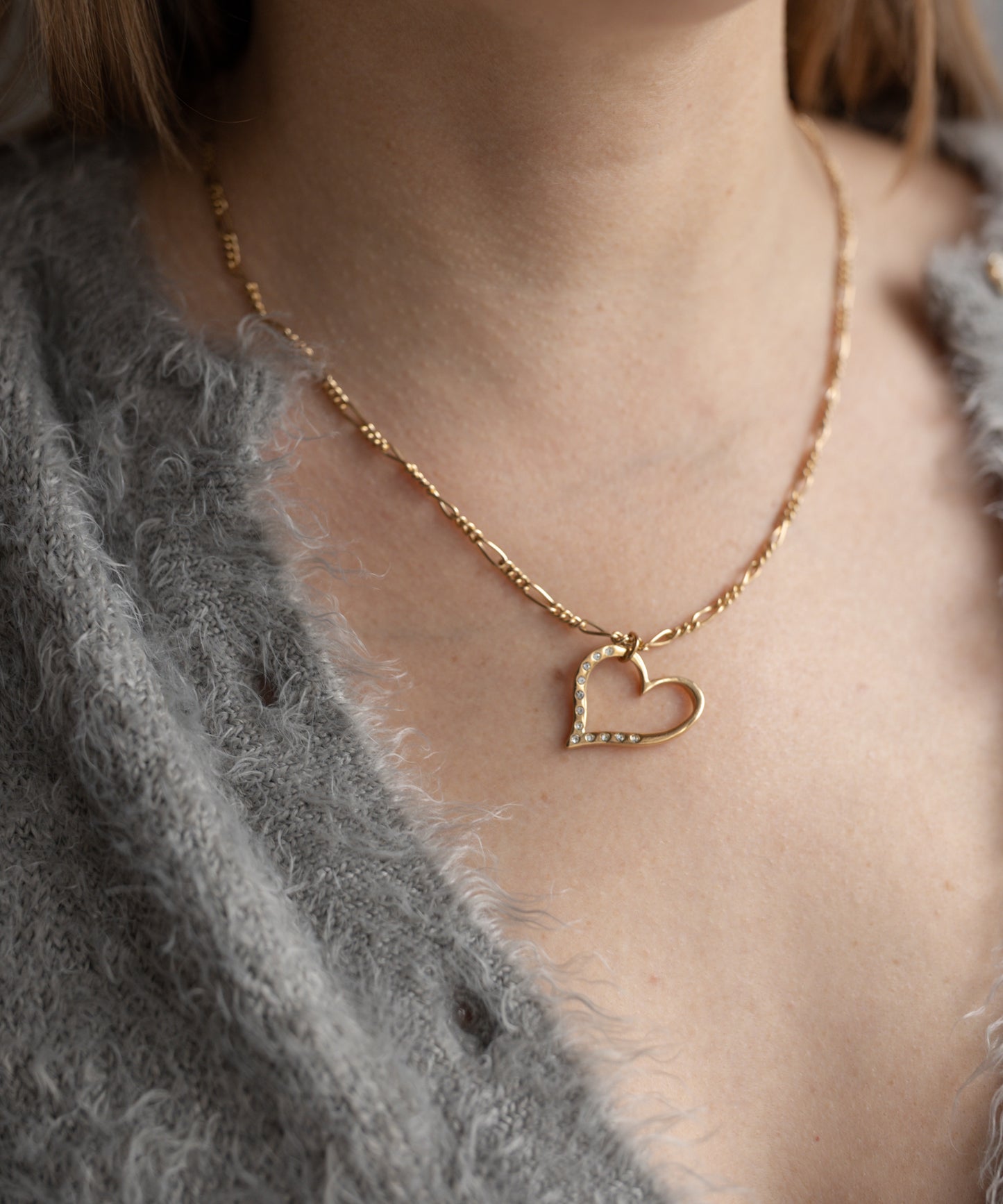 Close-up of a person wearing a grey sweater and WALD Berlin’s Valentine’s Day special sketch heart necklace, ideal as a romantic gift.