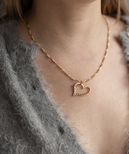 Close-up of a person wearing a grey sweater and WALD Berlin’s Valentine’s Day special sketch heart necklace, ideal as a romantic gift.