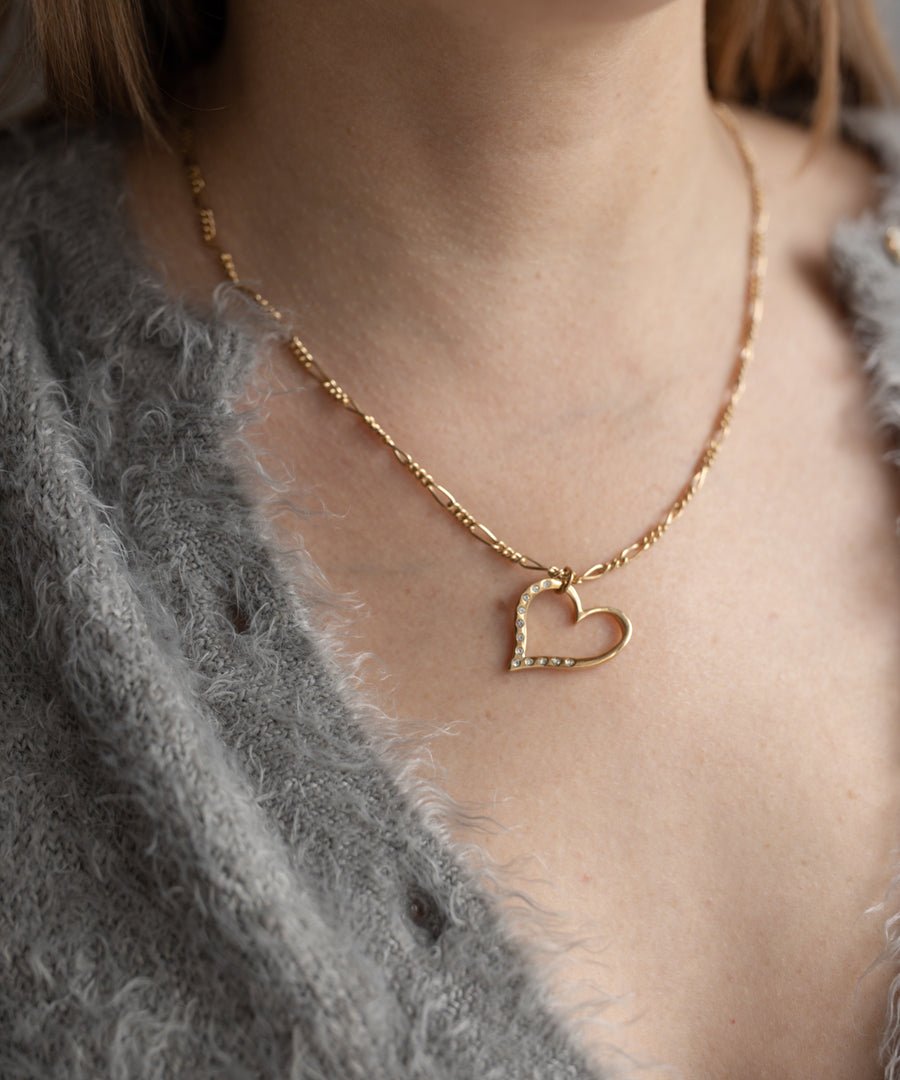 A person wearing the WALD Berlin SAMPLE SALE Valentine’s Day special sketch heart necklace, paired with a cozy grey fuzzy sweater.