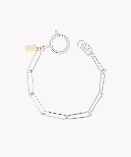 The SAMPLE SALE Ashley Bracelet Silver by WALD Berlin features elongated oval links, a round clasp, and a small rectangular tag.