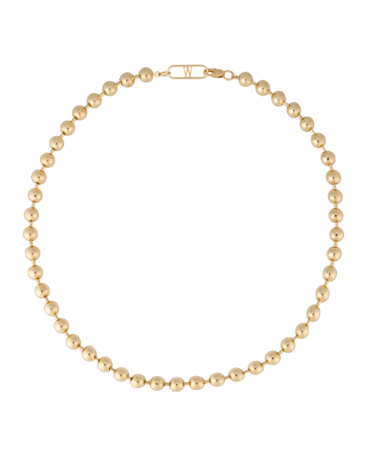 The Harry Necklace Gold by WALD Berlin, showcasing a circular arrangement of striking gold beads made from recycled gold, is elegantly displayed against a black background.