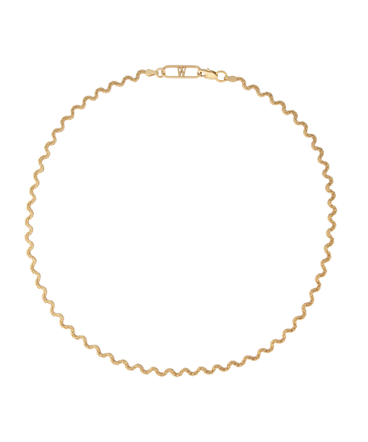 Elegant and thoughtfully designed, the WALD Berlin Irina Necklace Gold is a stunning German jewelry piece featuring a wavy gold design with a clasp. Made from graceful recycled gold, it is showcased against a black background for added allure.