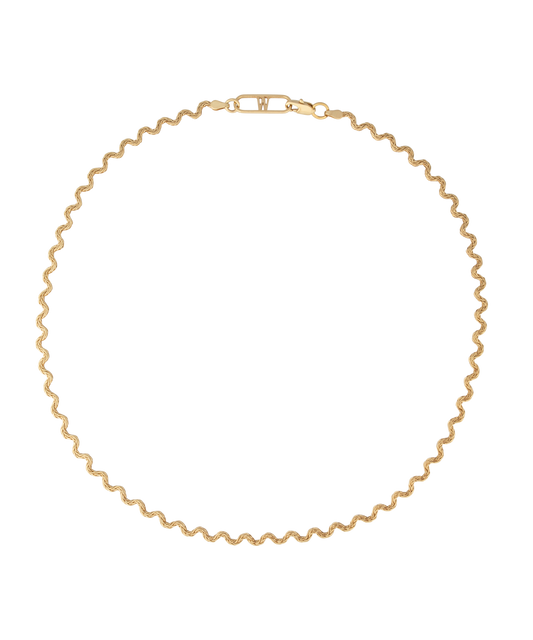 Elegant and thoughtfully designed, the WALD Berlin Irina Necklace Gold is a stunning German jewelry piece featuring a wavy gold design with a clasp. Made from graceful recycled gold, it is showcased against a black background for added allure.