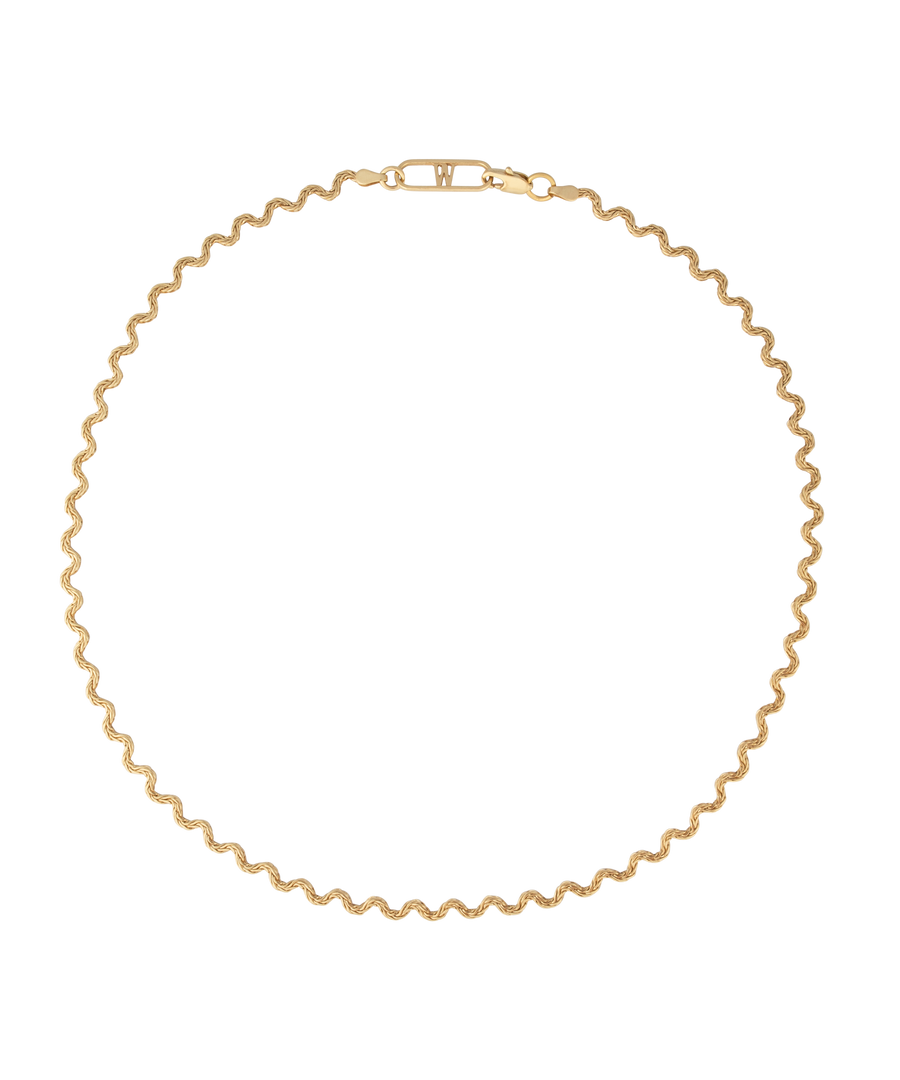 Elegant and thoughtfully designed, the WALD Berlin Irina Necklace Gold is a stunning German jewelry piece featuring a wavy gold design with a clasp. Made from graceful recycled gold, it is showcased against a black background for added allure.