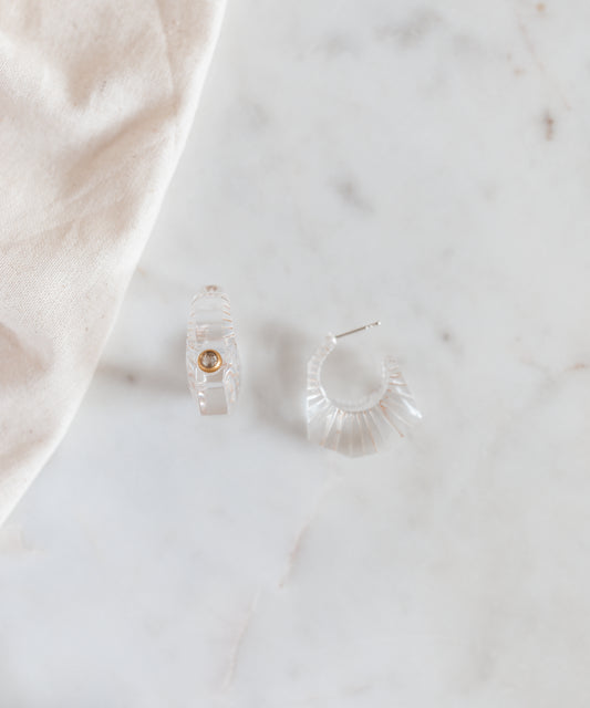 A pair of WALD Berlin crystal earrings prominently displayed on a marble table in Germany.