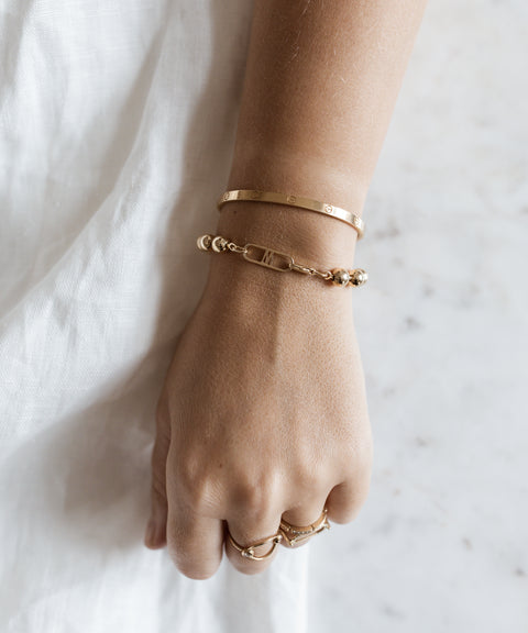 A woman's hand with two WALD Berlin Harry Gold Bracelets on it.