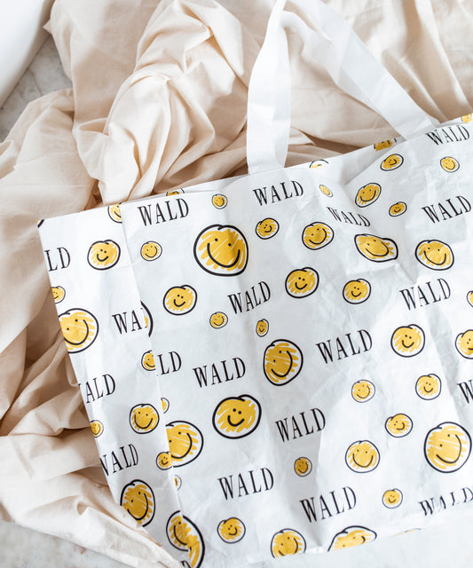 A yellow and white Smilie Dude Shopper jewelry made by WALD Berlin in Germany.