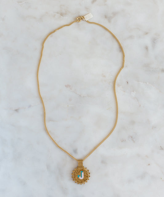 The WALD Berlin Sample saleSay My Name Gold Necklace features a gold-plated chain with a round turquoise and gold letter "J" pendant, displayed on light marble—a stylish initial necklace for any occasion.