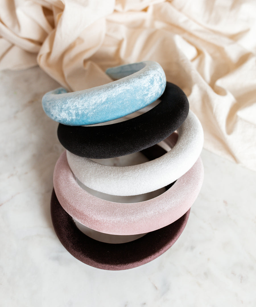 A set of four WALD Berlin Classic Light Blue Velvet Headbands on a white surface.