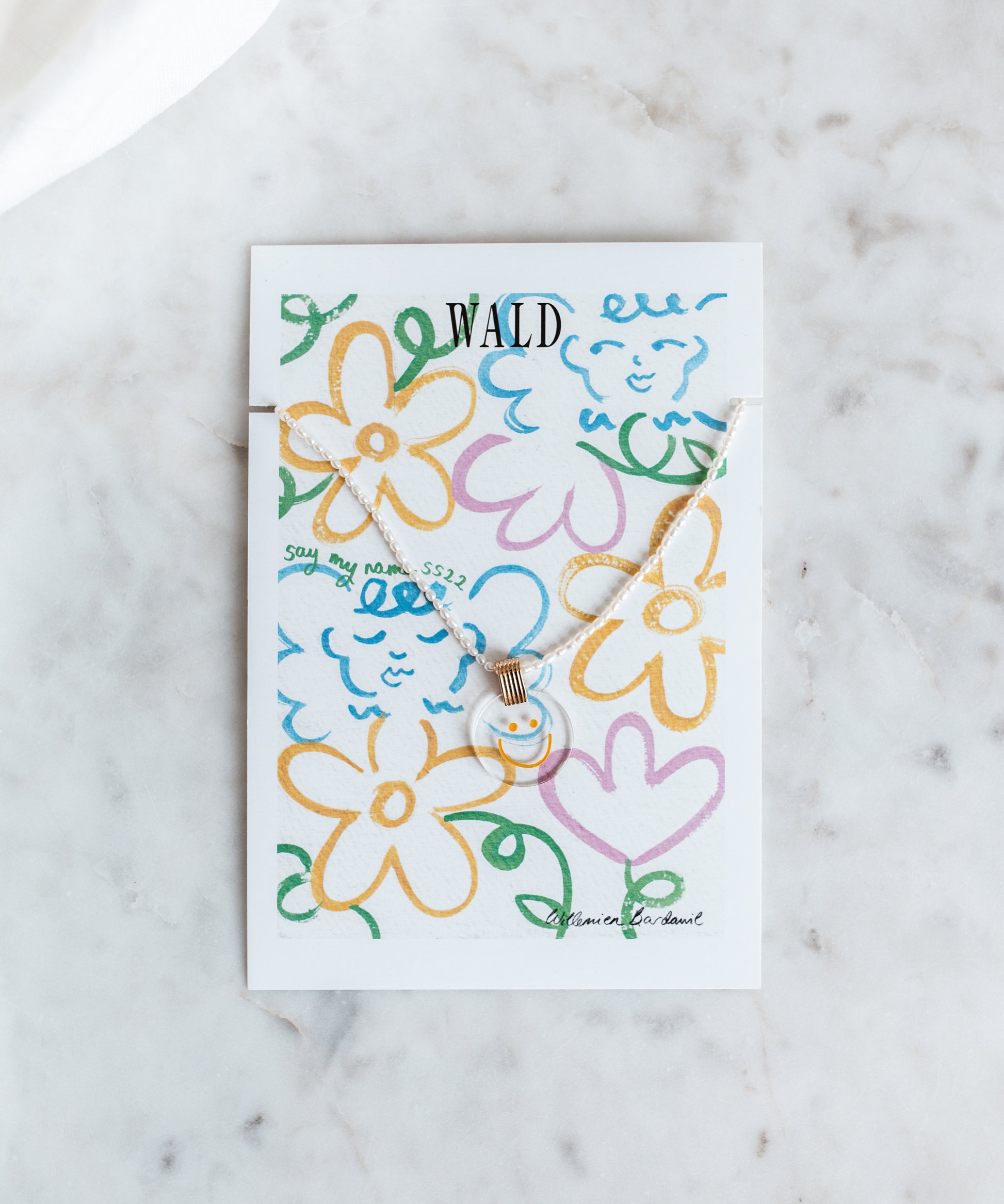 A card featuring the Smilie Dude Pearl Medaillon Necklace by WALD Berlin, inspired by the city's jewelry scene.