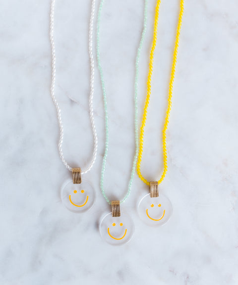 Three jewelry necklaces from WALD Berlin, featuring a smilie dude pearl medaillon design.