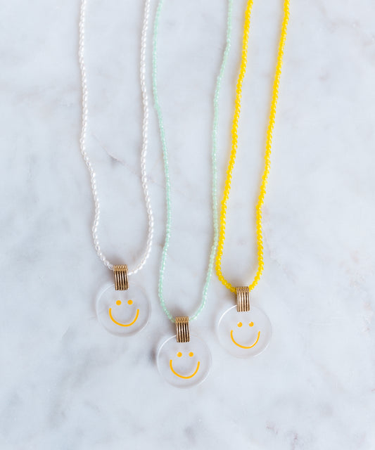 Three jewelry necklaces from WALD Berlin, featuring a smilie dude pearl medaillon design.