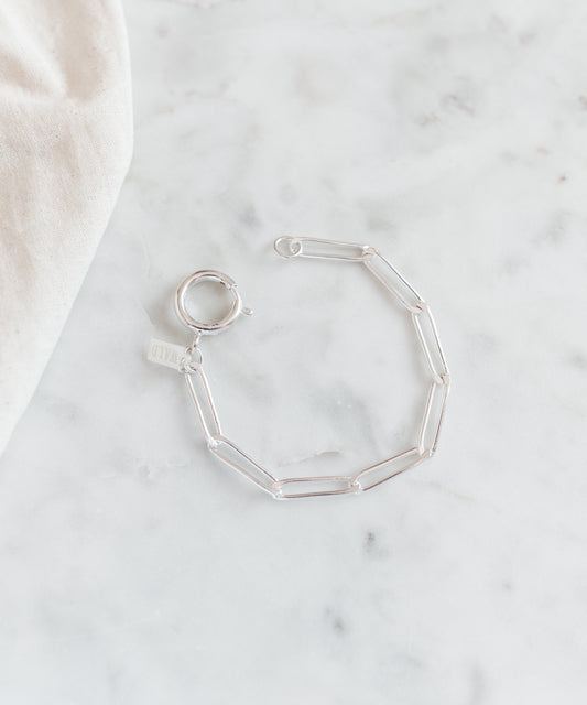 The SAMPLE SALE Ashley Bracelet Silver by WALD Berlin features a silver-plated chain and oversized clasp, shown on a white marble surface.