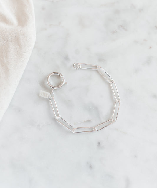 The SAMPLE SALE Ashley Bracelet Silver by WALD Berlin features a silver-plated chain and oversized clasp, shown on a white marble surface.
