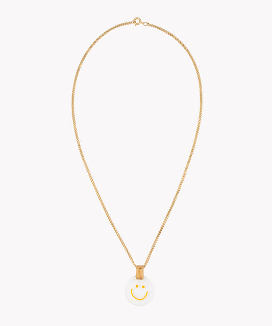 The Smilie Dude Medaillon Gold Necklace by WALD Berlin is an 18k gold-plated chain piece, showcasing a precisely crafted white circular medallion adorned with a yellow smiley face, made in Germany.