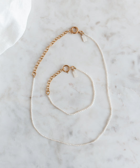 A WALD Berlin jewelry necklace with fine rice pearls displayed on a marble table in Germany.