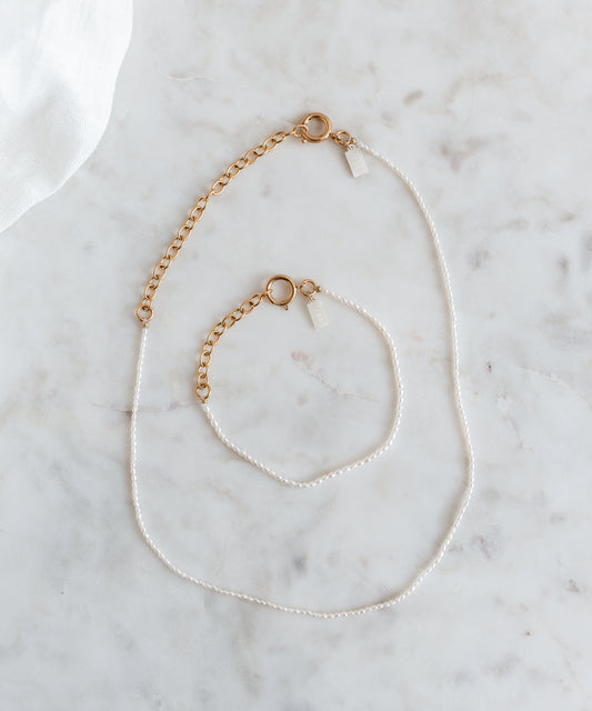 A WALD Berlin jewelry necklace with fine rice pearls displayed on a marble table in Germany.